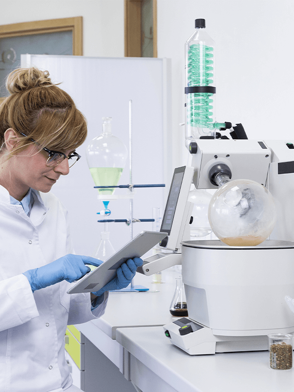 Female lab worker in white coat checking a file.
